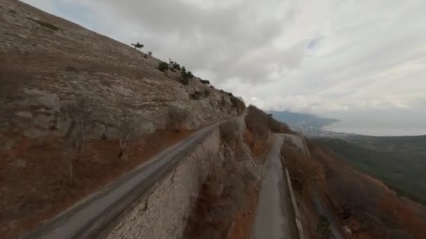Tiro aéreo de esportes de alta velocidade fpv drone branco suv carro dirigindo na estrada serpentina natural — Vídeo de Stock