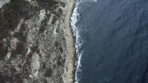 Tiro da elicottero sorvolando la costa naturale con mare ondulato e scogliera terreno roccioso — Video Stock