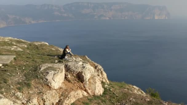 Casal relaxado descansando no topo do penhasco alto comendo shawarma contemplando paisagem incrível céu do mar — Vídeo de Stock