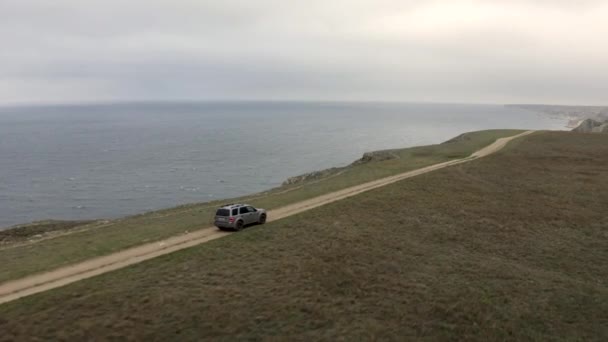 Aerial side tracking shot wysokiej prędkości samochód suv jazdy na szczycie drogi górskiej naturalne niebo krajobraz morski — Wideo stockowe