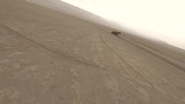 Повітряні сліди стріляли двома екстремальними гоночними машинами на піщаній пустелі в оточенні пилу і смогу — стокове відео