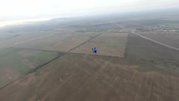 Luchtfoto skydiver in wingsuit springen met parachute uit hete lucht ballon over landbouw veld — Stockvideo
