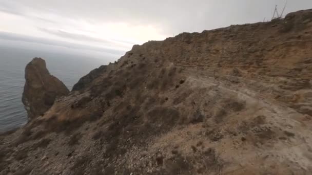Bruine rotsachtige steile kliffen met onverharde wegen en kleine struiken — Stockvideo