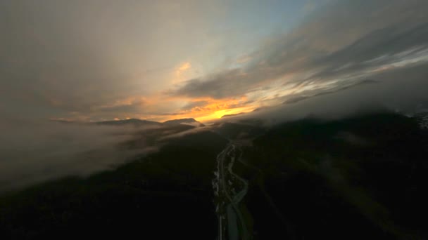 Brede snelweg tussen bossen onder mist tegen zonsondergang — Stockvideo