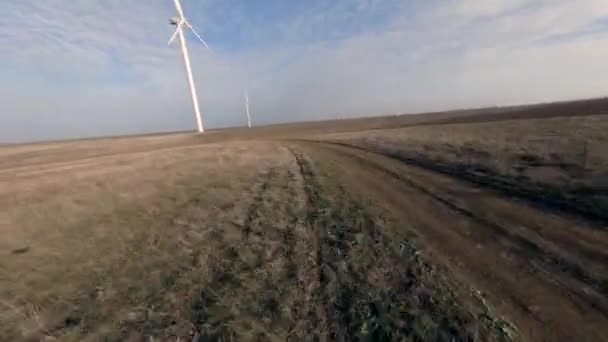 大きなブレードを持つ白い風車は、茶色の牧草地に立つと反転回転 — ストック動画