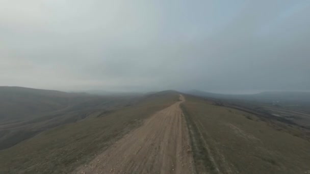 Os veículos de buggy dirigem ao longo da estrada terrestre marrom entre os campos. Fpv drone aéreo — Vídeo de Stock