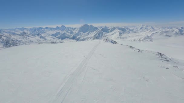 Flygfoto snowboard spår av snö bergssluttning på naturligt landskap klarblå himmel — Stockvideo