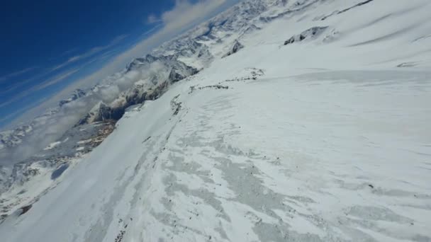 Sobre el vuelo fpv movimiento de buceo nevado cuesta abajo alta montaña natural — Vídeos de Stock
