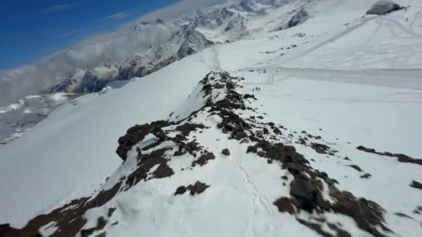 Стрельба с дрона fpv активных людей, взбирающихся на пик Эльбрус, идущих по снежному маршруту — стоковое видео