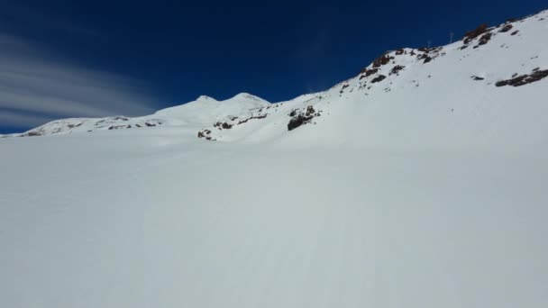 Aerea fpv drone vista montagna innevata Elbrus paesaggio cinematografico picco con pista da sci — Video Stock