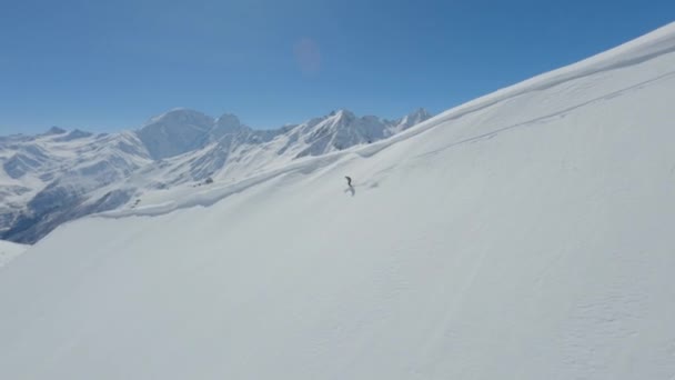 Letecké sledovat pohled aktivní freerider na lyžích na horním hřebeni sjezdu — Stock video