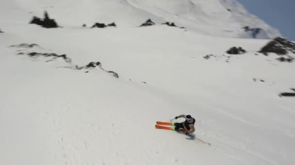 Aerial fpv drone pandangan profesional skier naik ski gunung menyelam dari tebing alam epik bersalju — Stok Video