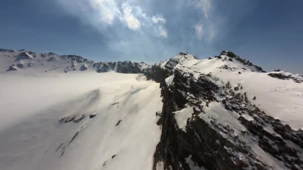 Letecký fpv drone pohled let poblíž ostrého vrcholu útesu divoké nekonečné horské údolí v slunné zimě — Stock video