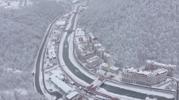 Vista aérea cinemática invierno ciudad estación de esquí rodeado de paisajes alpinos de montaña — Vídeo de stock