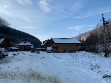 Dağlarda dağ evi, karlı bir arka planda.