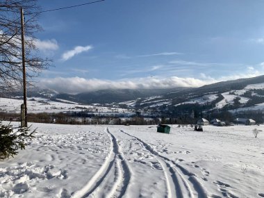 Dağlardaki yol küçük kar köyünü bulutlandırıyor. Panorama.