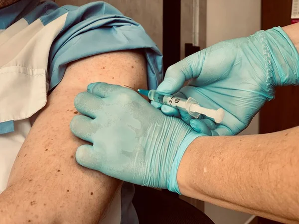 클리닉에서 코로나 바이러스 백신을 환자입니다 의사는 환자의 어깨에 주사나 백신을 — 스톡 사진