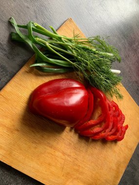 Yeşil taze dereotu, kırmızı biber ve gri arka planda yeşil soğan. Yakın plan..