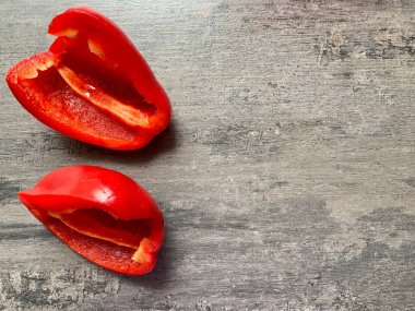 Gri arka planda iki yarım kırmızı dolma biber. Yakın plan. Boşluğu kopyala.
