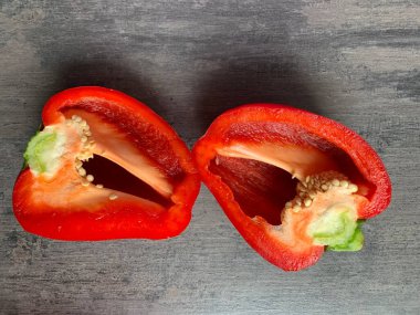 Gri arka planda iki yarım kırmızı dolma biber. Yakın plan. Boşluğu kopyala.