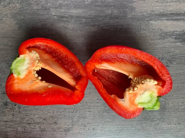 Gri arka planda iki yarım kırmızı dolma biber. Yakın plan. Boşluğu kopyala.