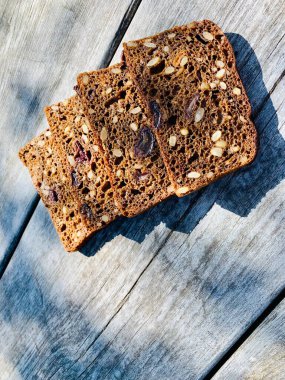 Tahta zemin üzerinde tohumlar olan dilimlenmiş ekmek parçaları..