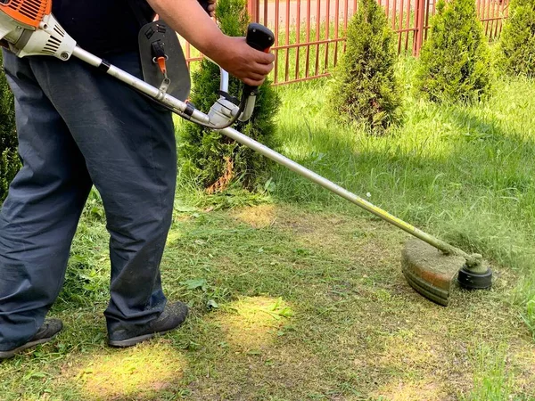 Seorang Pekerja Memotong Rumput Hijau Dengan Pemangkas Bensin Taman Atau — Stok Foto