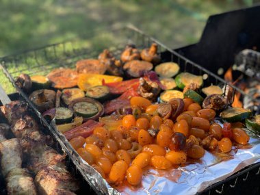 Izgara sebzeler yakın plan. Domates, mantar ve biber, yakın plan kabak ızgarada pişirilir, ateşin üzerinde tütsülenir..