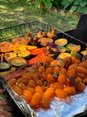 Izgara sebzeler yakın plan. Domates, mantar ve biber, yakın plan kabak ızgarada pişirilir, ateşin üzerinde tütsülenir..