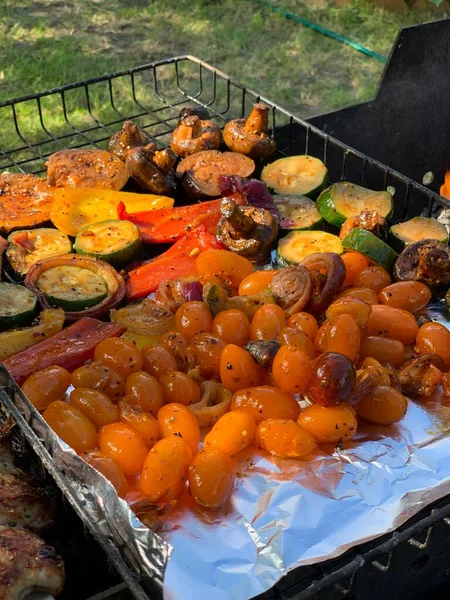 Izgara sebzeler yakın plan. Domates, mantar ve biber, yakın plan kabak ızgarada pişirilir, ateşin üzerinde tütsülenir..
