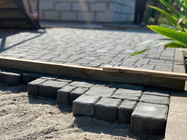 Construction or renovation of the sidewalk and road. Laying decorative road tiles.
