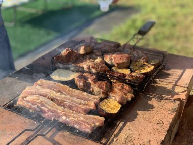 The process of grilling meat. Barbecue meat on the grill summer evening close up