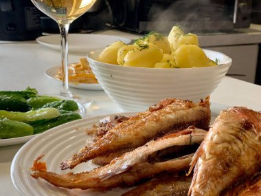 Kızarmış balık, haşlanmış taze patates, hafif tuzlanmış salatalık..