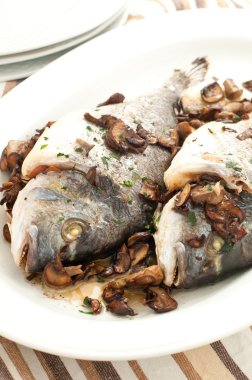 Baked sea bream with mushrooms and parsley