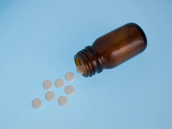 White pills poured out of bottle — Stock Photo, Image