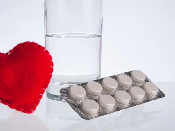 Corazón, vaso de agua y pastillas — Foto de Stock