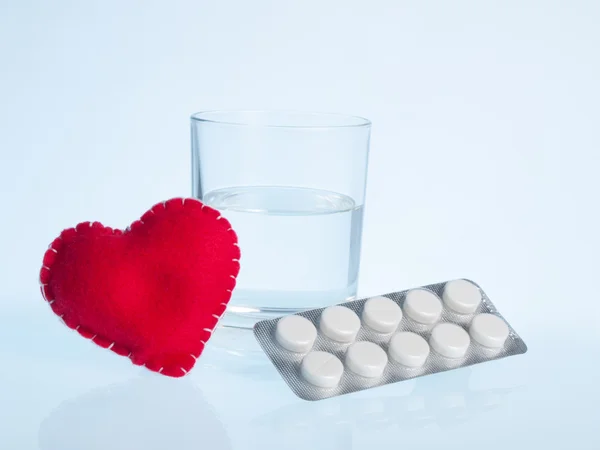 Corazón, vaso de agua y pastillas — Foto de Stock