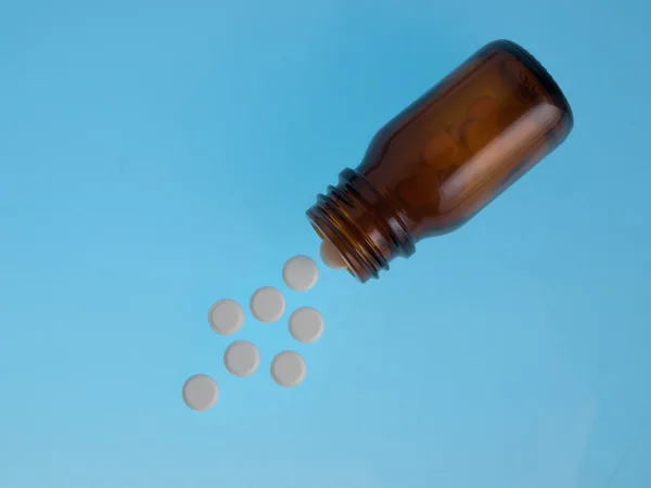 White pills poured out of bottle — Stock Photo, Image