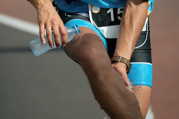 Athlète verser de l'eau sur lui-même pour se refroidir après avoir couru — Photo