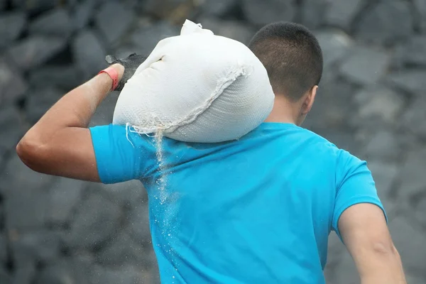 Jonge man die scheur zandzak — Stockfoto