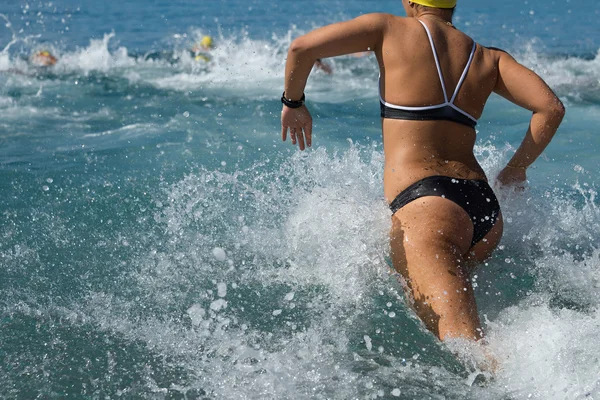 Mulher correndo na água na competição de natação — Fotografia de Stock