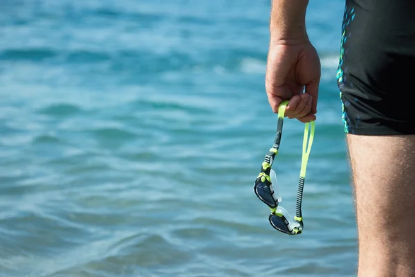 Nadador con gafas de natación en la mano en la entrada al mar — Foto de Stock