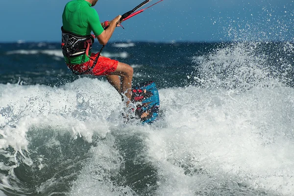 Kitesurfer overcome big wave in the ocean — Stock Photo, Image
