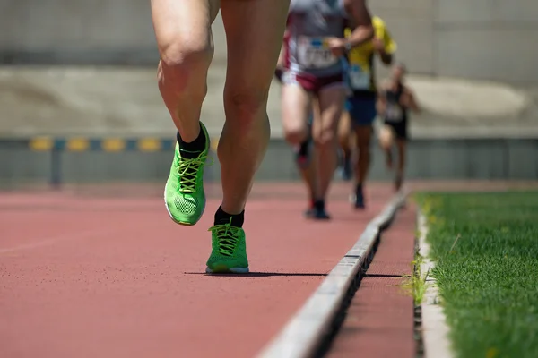 Atletiek mensen die rennen op de baan veld — Stockfoto