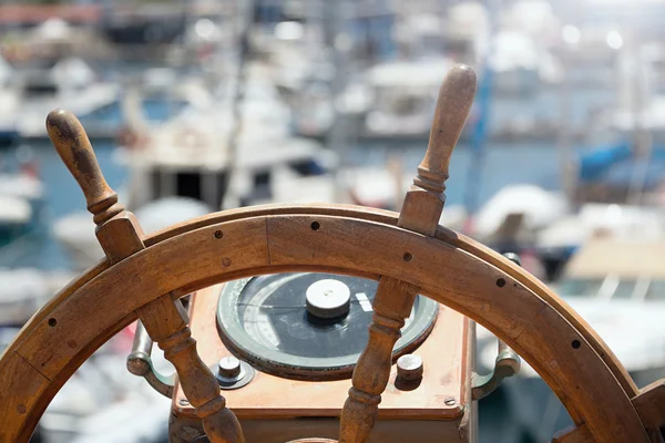 Captains steering wheel of an old wooden sailing ship in a port