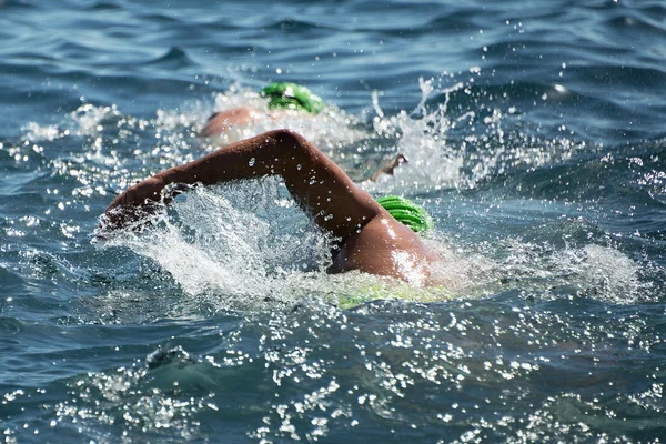 Triathlon swimmers churning up the water — Stock Photo, Image