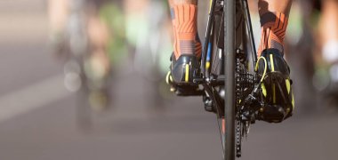 Bisiklet yarışında yarışan sporcular yüksek hızda yarışırlar, bisiklet ayakkabılarının ayrıntıları...