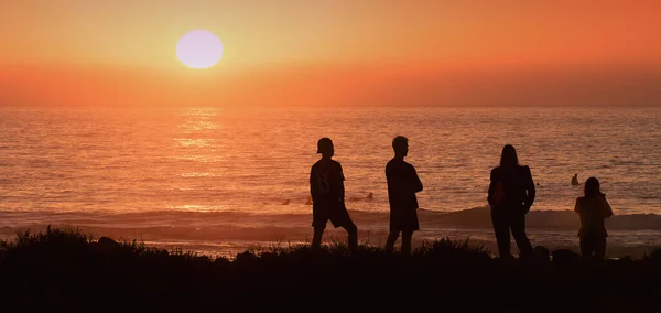 Plaj Tatilindeki Arkadaşlarının Silueti Güvenli Bir Mesafeden Gün Batımını Seyrediyor — Stok fotoğraf