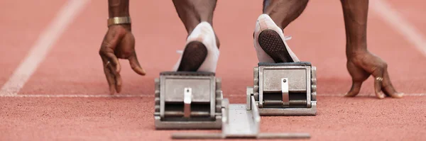 Back view of male feet on starting block ready for a sprint start