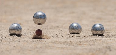 Petanque top bulvarları toz zeminde kaseler, çarpma anında fotoğraf. Toplar ve küçük bir tahta kriko.